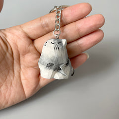 Hand holding an adorable wooden cat keychain