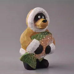 Side view of wooden bear figurine holding fish