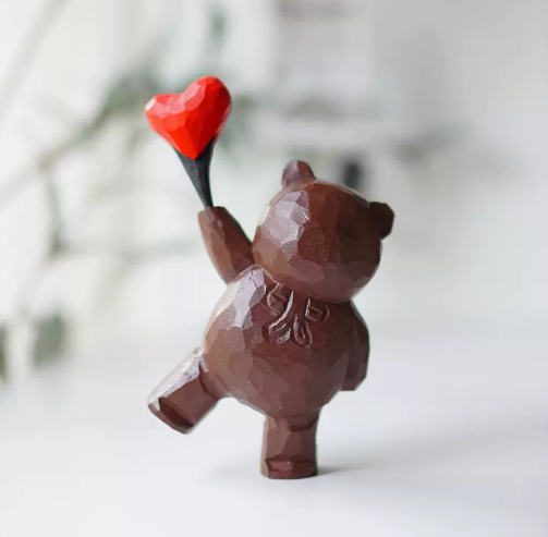 bear figure with heart balloon