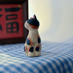 Side profile of hand-carved calico cat wooden figurine