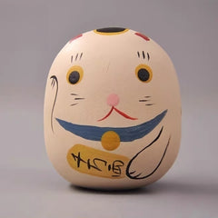 Cat daruma doll with raised paw and painted whiskers