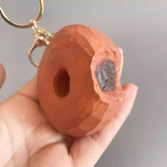 close view of carved bite texture on wooden donut keychain