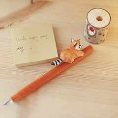 The animal wood pen sits flat on the table and complements the note pad.