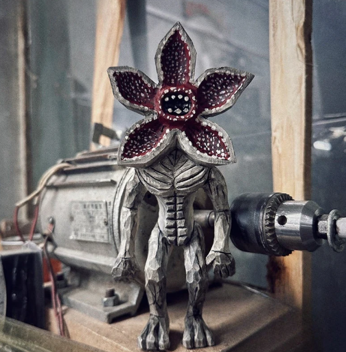 Hand-carved Demogorgon wooden figurine on workbench