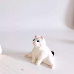 Mini cat figurine sitting with legs stretched