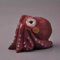 Mini red octopus wood sculpture viewed from front, hand-carved with smooth finish.
