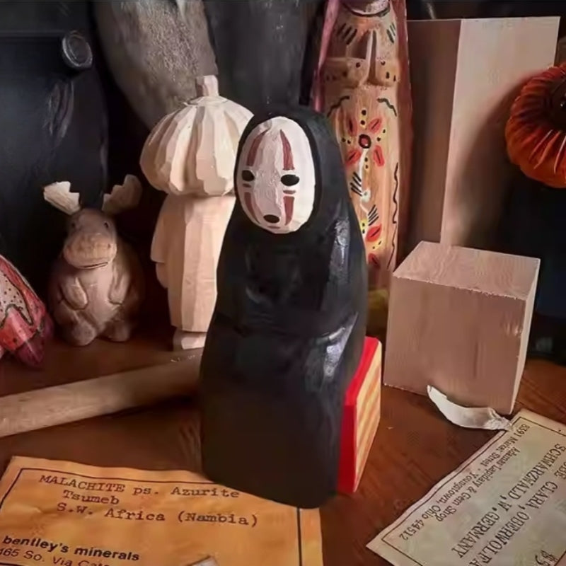 Hand-carved No Face Figure wooden sculpture displayed among other artisan figurines.