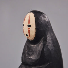 Close-up of the No Face Figure’s hand-carved face and black cloak detail.