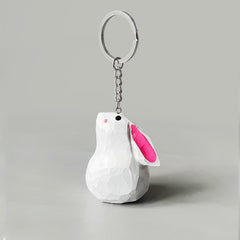 A white bunny keychain with pink ears, hanging from a silver chain and keyring.