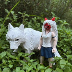 wooden Princess Mononoke figurine with white wolf in natural setting