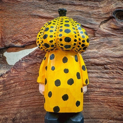 Yellow polka dot pumpkin head wooden figurine against wood texture