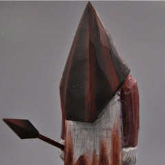 Close-up of the Pyramid Head wooden horror figure, highlighting the textured wooden helmet and painted details.