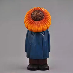 Hand-carved wooden figure with a sunflower head and blue coat, front view.