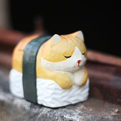 Sushi sleeping cat sculpture on the windowsill.