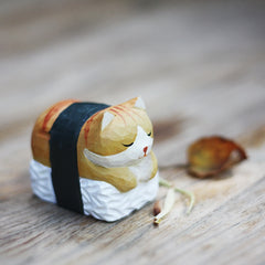 Sushi sleeping cat figurine placed on a table in the garden.