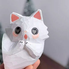 Tilted head cat figurine in hand