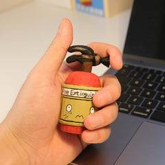 Svn Futures  fire extinguisher figurine held in hand for size reference
