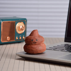 Hand-painted wooden poop toy on crafting table, showcasing a playful design and quality wood craftsmanship.