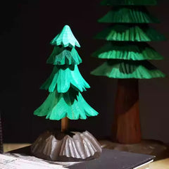 Hand-carved wooden Christmas tree decoration with tiered green branches and a detailed brown base, perfect for tabletop holiday décor.