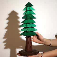 Large wooden Christmas tree with carved layers shown for scale, handcrafted from solid wood for festive home accents.