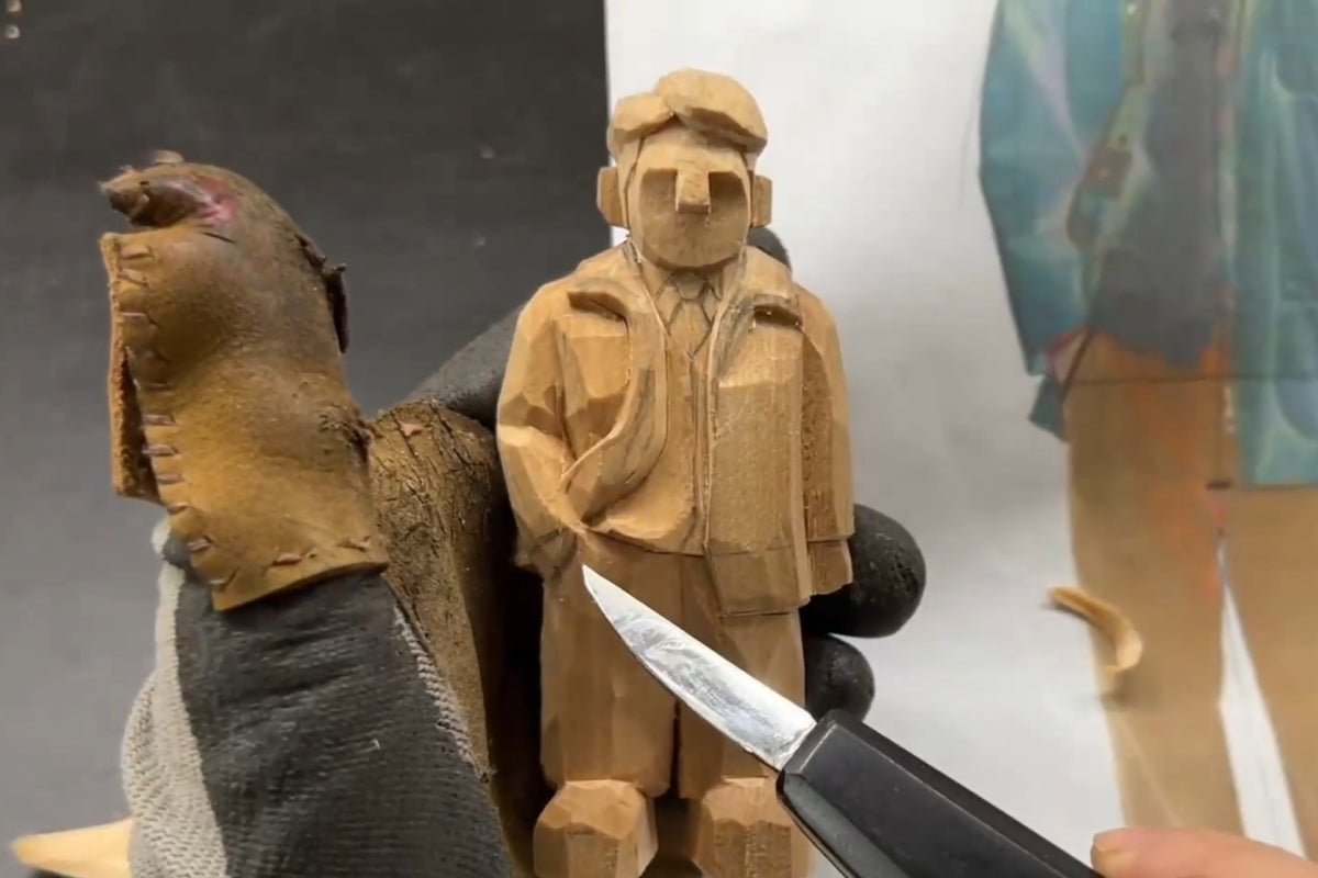 Refining vest and pocket depth while adjusting proportions on a custom wood figurine—essential work in handcrafted wooden sculpture.