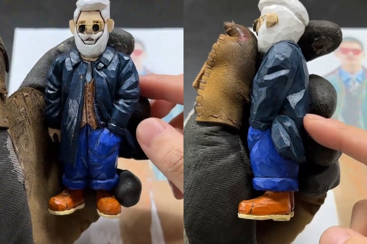 Painted wooden figurine with continuous coat folds carved across the arm and back, showcasing finished wood carving details.