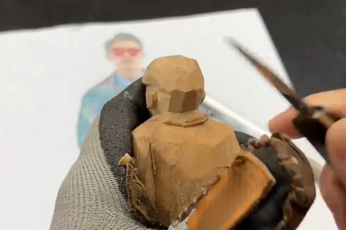 Carving around the collar of a wooden sculpture, emphasizing layering for hand carved wooden gift figurines.