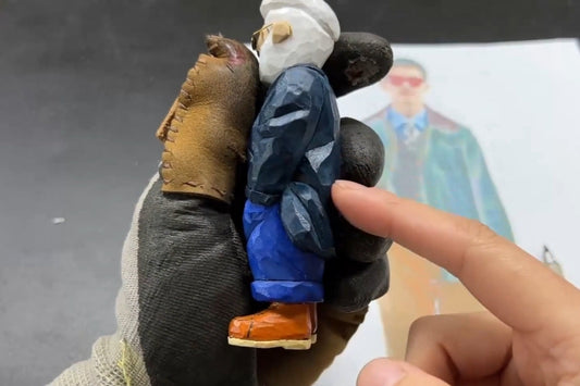 Painted Svn Futures  gifts figurine showing detailed clothing folds and coat-to-arm transitions in wood carving.