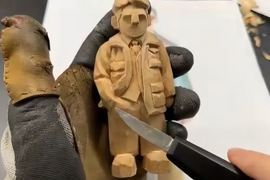 Hand-carving a wooden figurine with one hand in its pocket, showcasing detailed jacket and pants folds